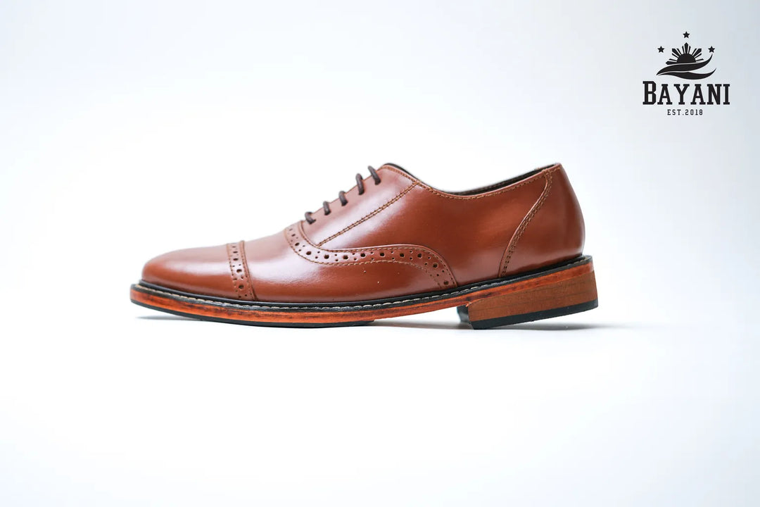Brown leather shoe on a white background with Bayani logo.

