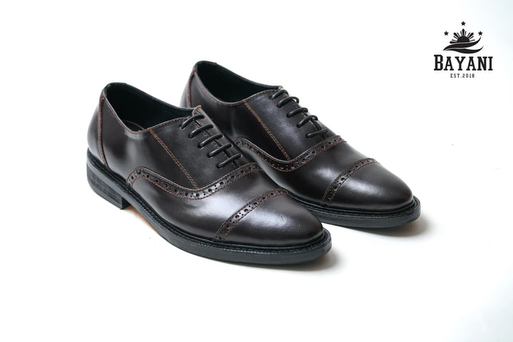 Pair of brown leather dress shoes on a white background with Bayani logo.

