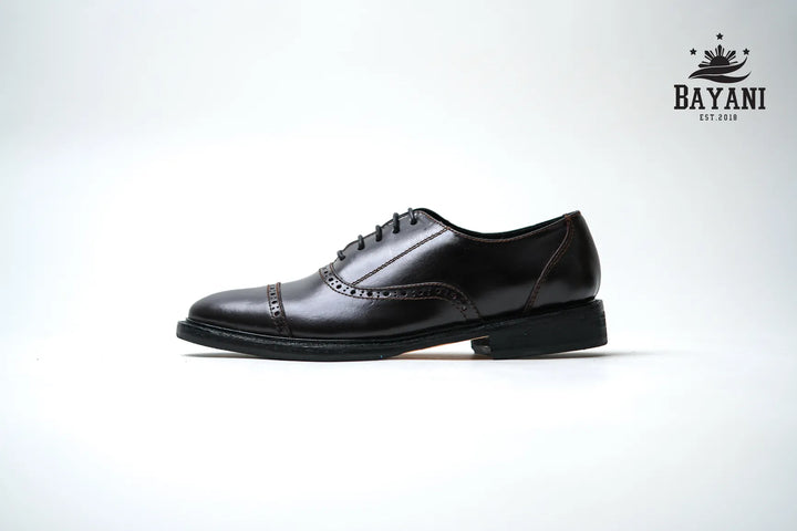 Black leather dress shoe on a white background with Bayani logo.

