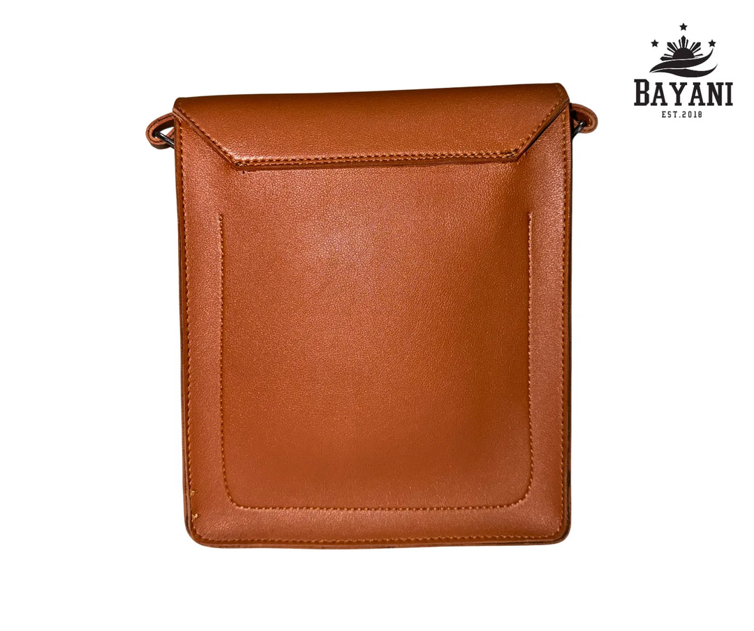 Brown leather crossbody bag on a white background with Bayani logo.
