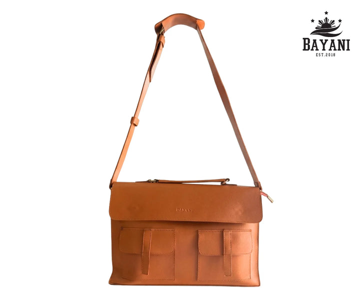 Tan Brown leather bag with a strap on a white background, featuring the Bayani brand.

