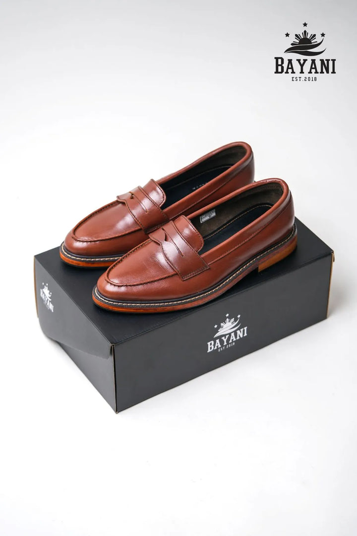 Brown loafers on a black box with Bayani logo on a white background
