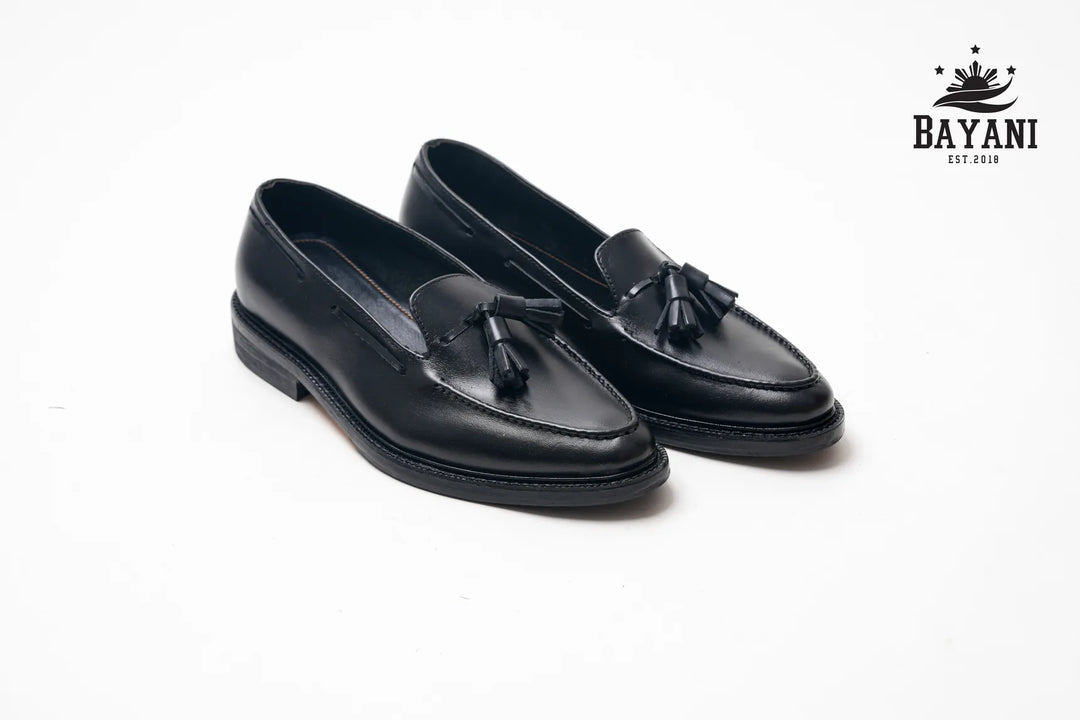 Pair of black loafers with tassels on a white background, featuring the Bayani brand logo.
#color_all-black