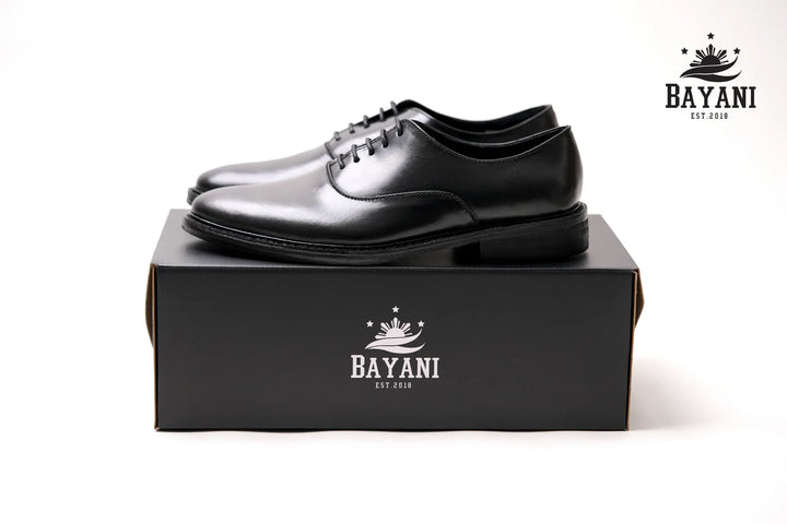 Black dress shoes on a black box with Bayani logo on a white background
