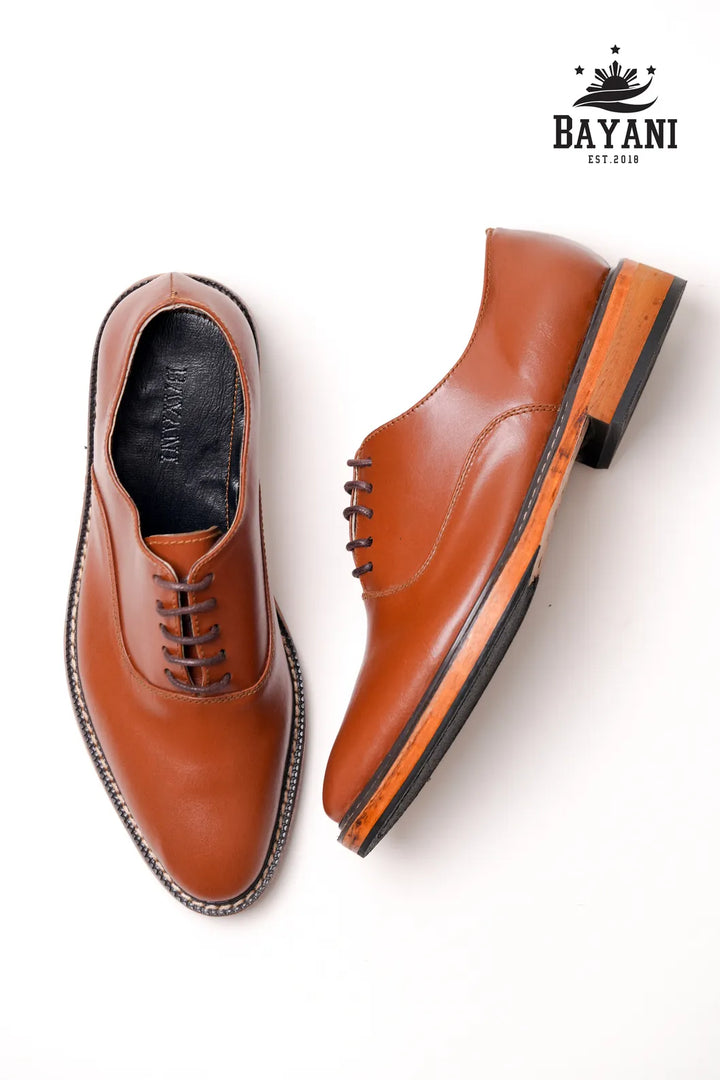 Brown leather shoes with black soles on a white background, featuring the Bayani brand.
