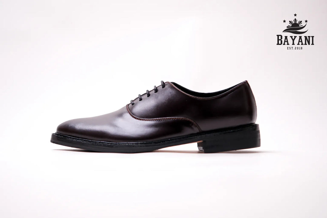 Brown leather shoe on a white background with Bayani logo.
