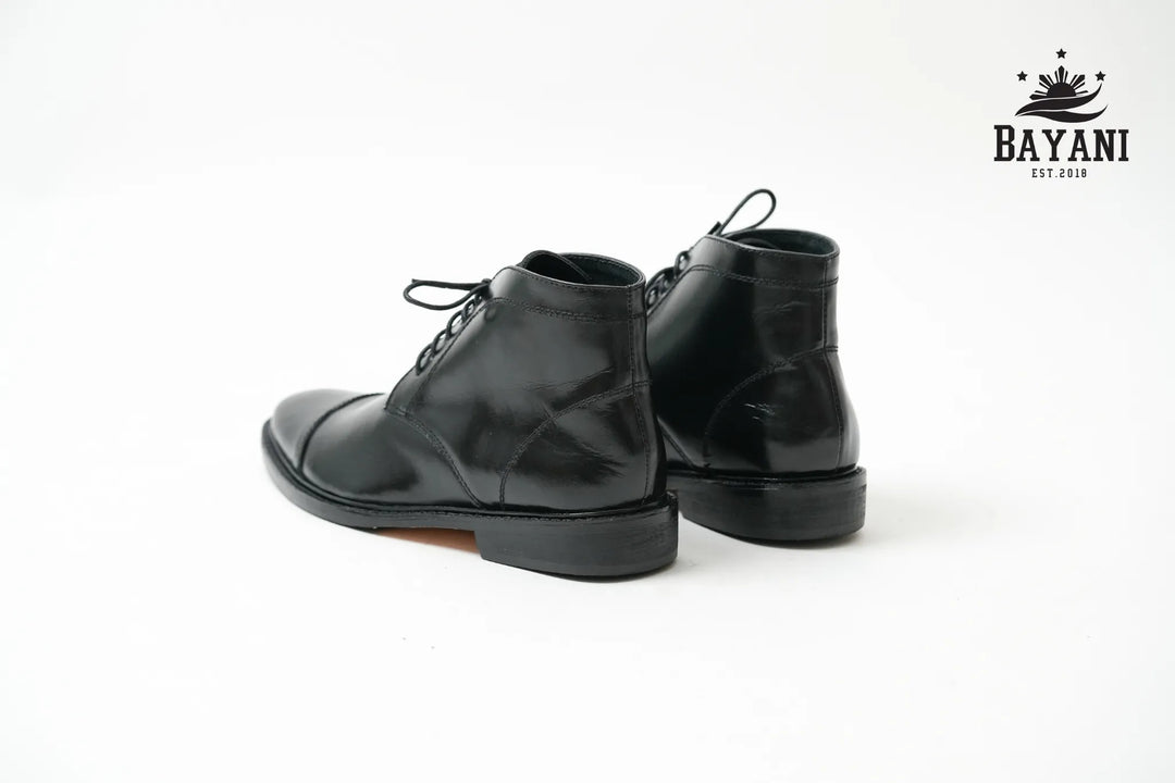 Black leather boots on a white background with Bayani logo.

