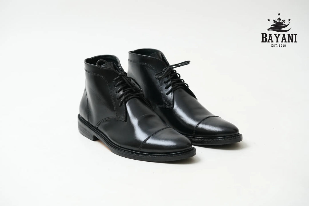 Pair of black leather dress boots on a white background with Bayani logo.
#color_black