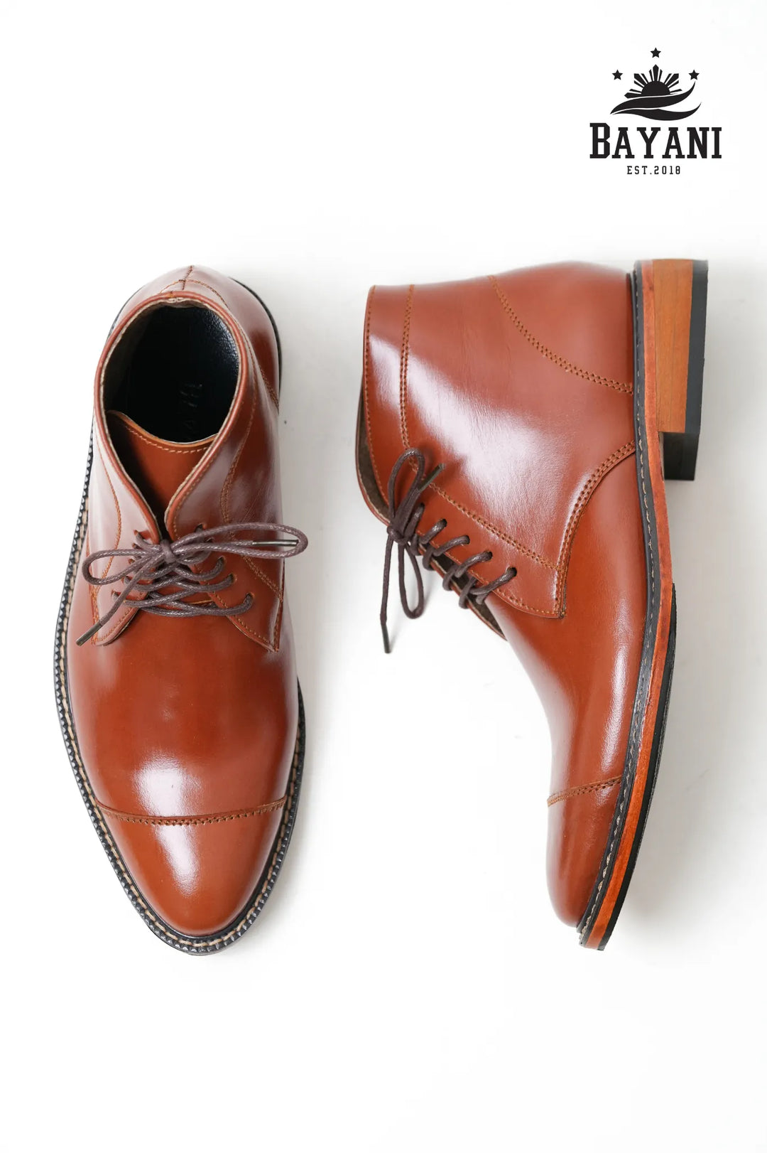 Pair of brown leather shoes with a white background and Bayani logo.
