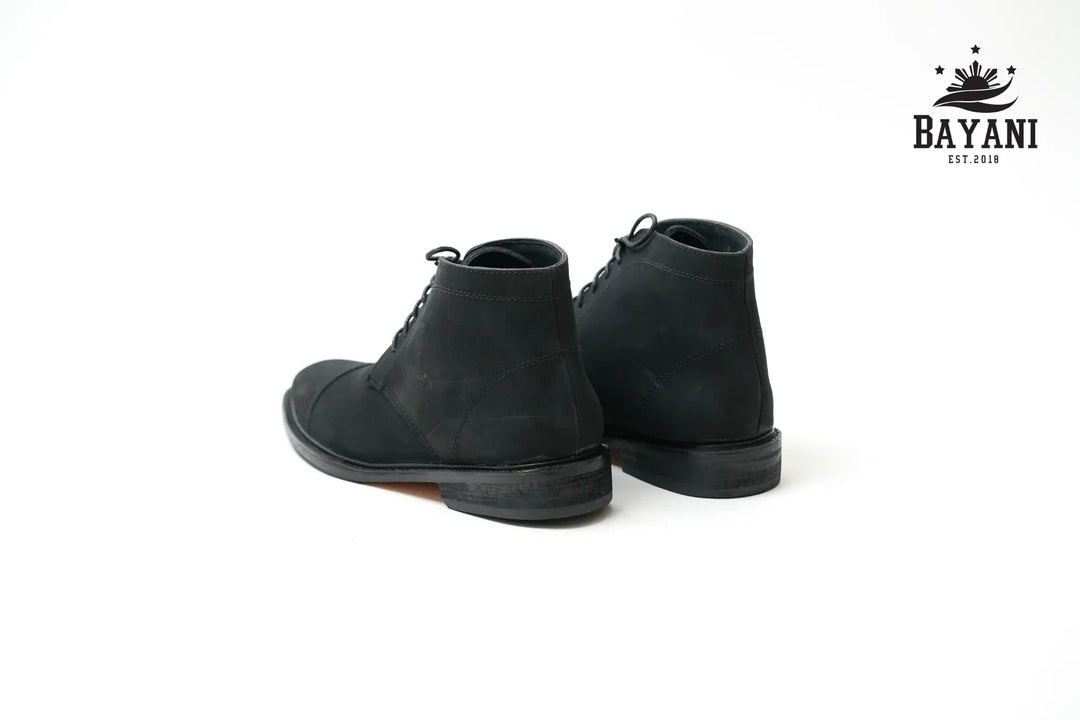 Black boots on a white background with Bayani logo.
