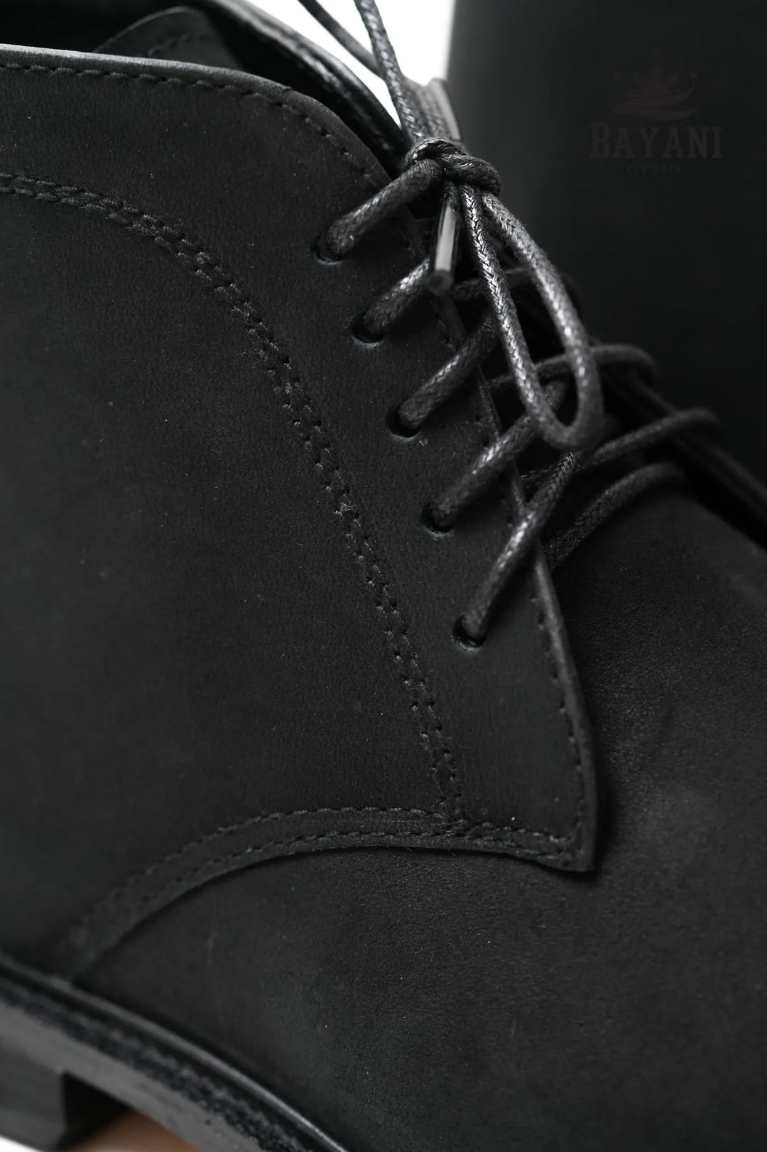 Close-up of black leather boot with laces and &