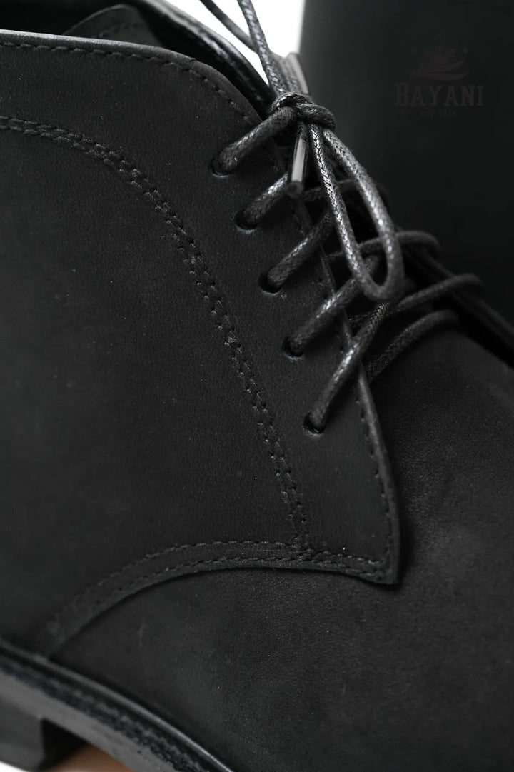 Close-up of black leather boot with laces and &