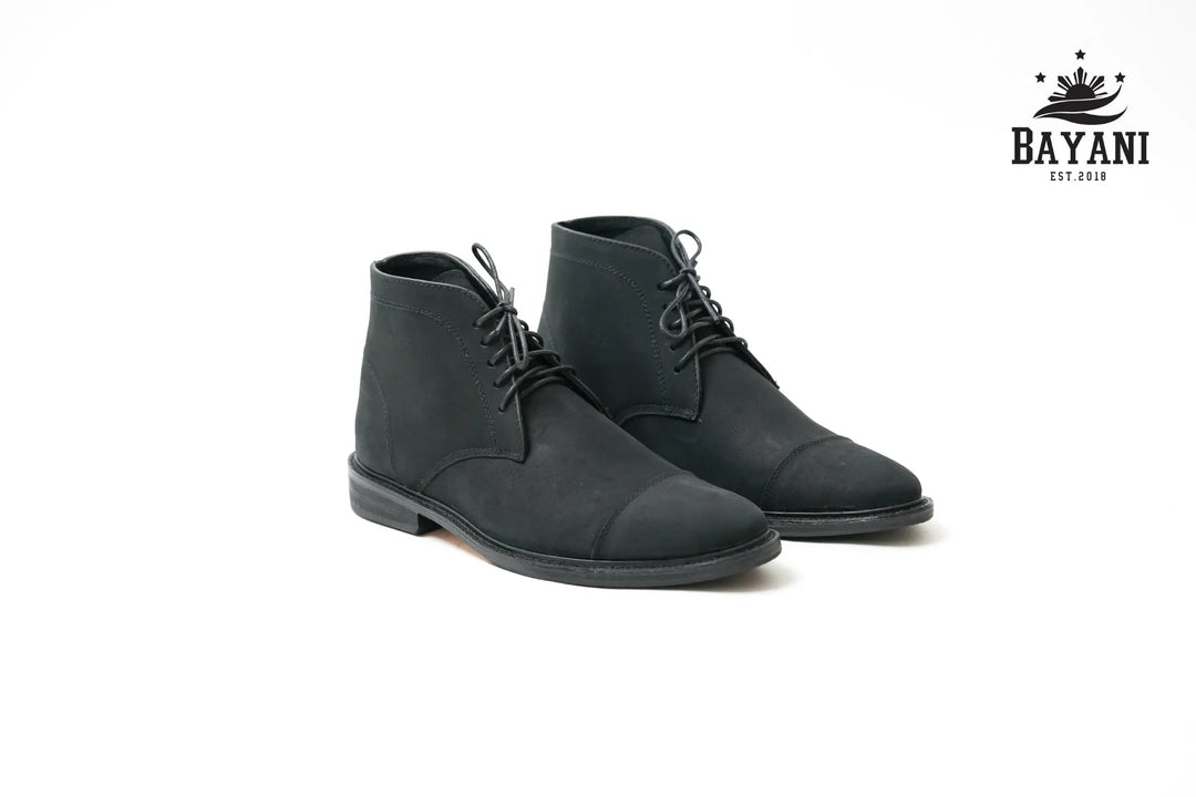 Pair of black leather boots on a white background with Bayani logo.
