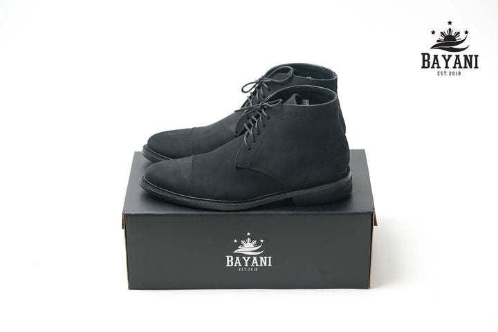 Black dress shoes on a black box with Bayani logo on a white background
