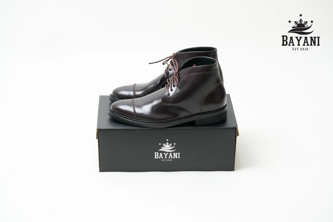 Black leather boots on a black box with Bayani logo on a white background

