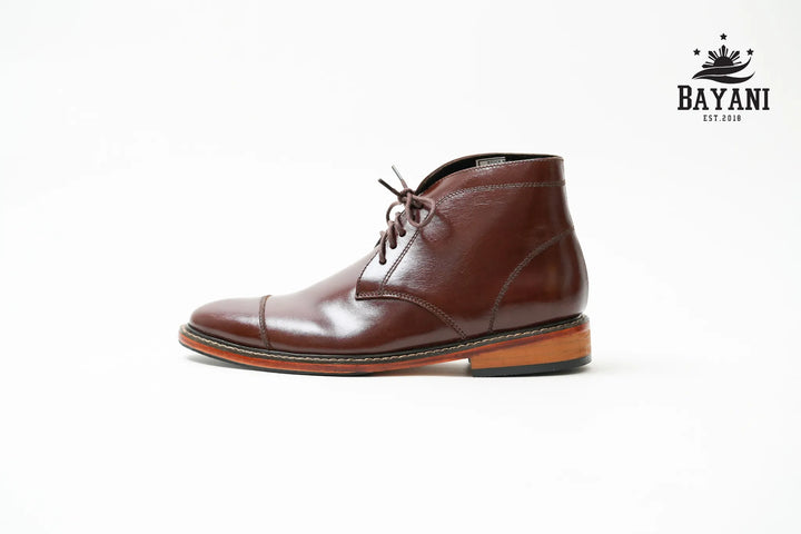Brown leather boot on a white background with Bayani logo.
