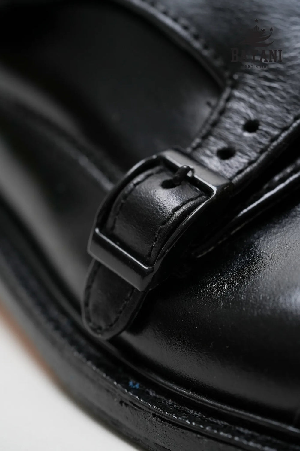 Close-up of a black leather shoe with a buckle, featuring the Bayani logo.
#color_black