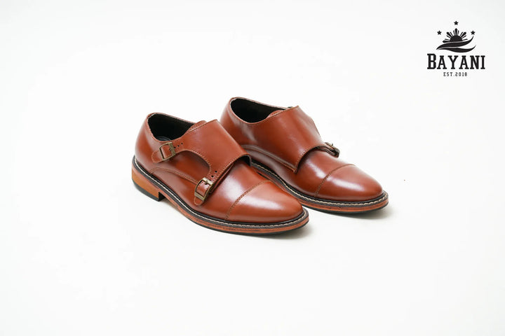 Pair of brown leather shoes with a visible brand logo on a white background
