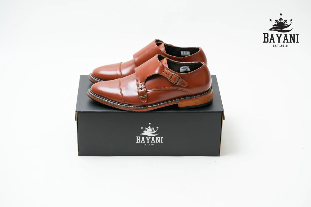 Brown leather shoes on a black box with Bayani logo on a white background
