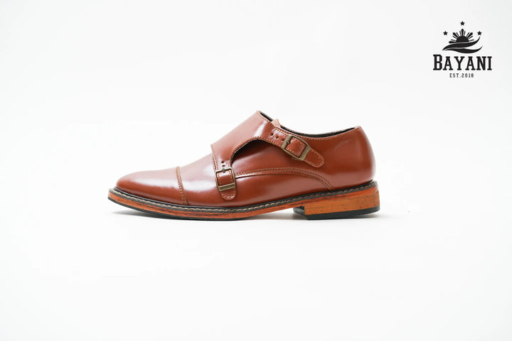 Brown leather shoe with a strap on a white background, featuring the Bayani brand.
