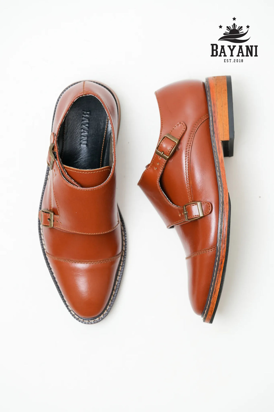 Pair of brown leather shoes with a visible brand logo on a white background

