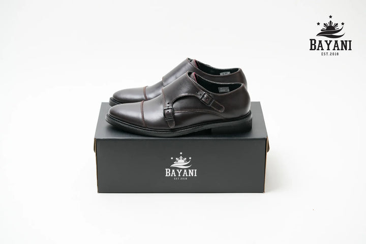 Black leather shoes on a black box with Bayani logo on a white background
