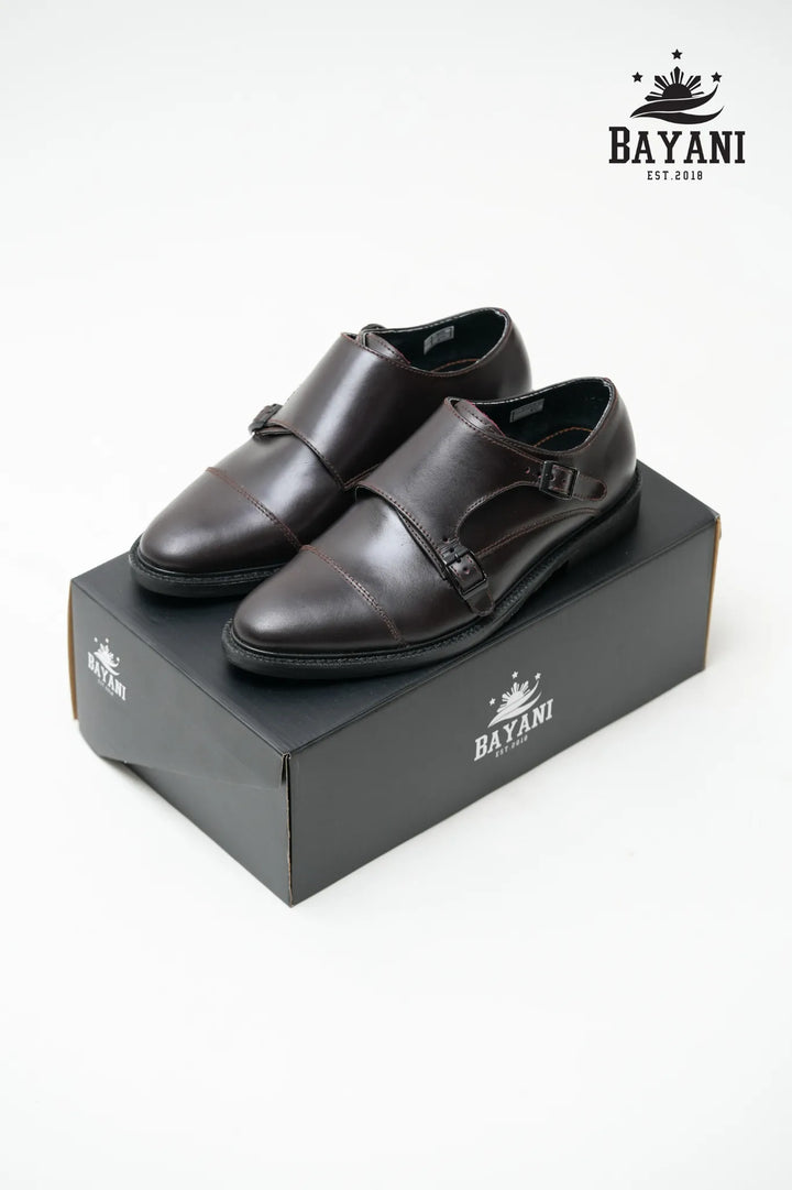Pair of black dress shoes on a Bayani branded box with the Bayani logo above.
