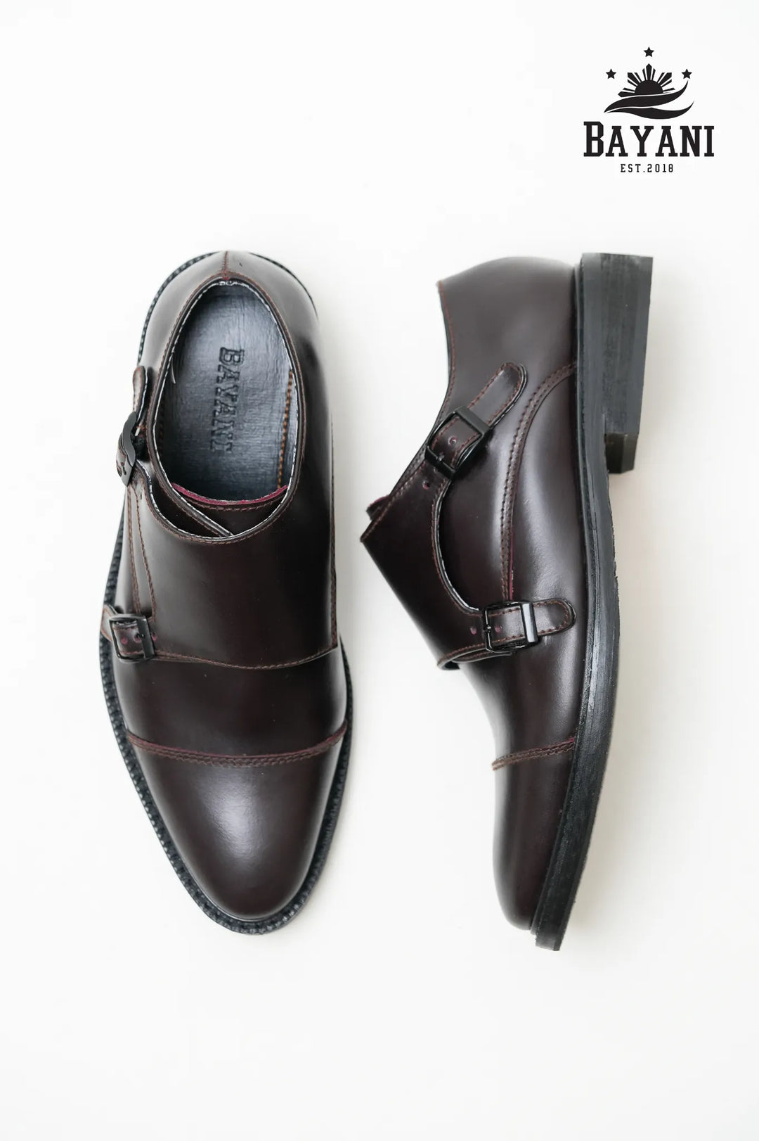 Brown monk strap shoes on a white background with Bayani logo.
