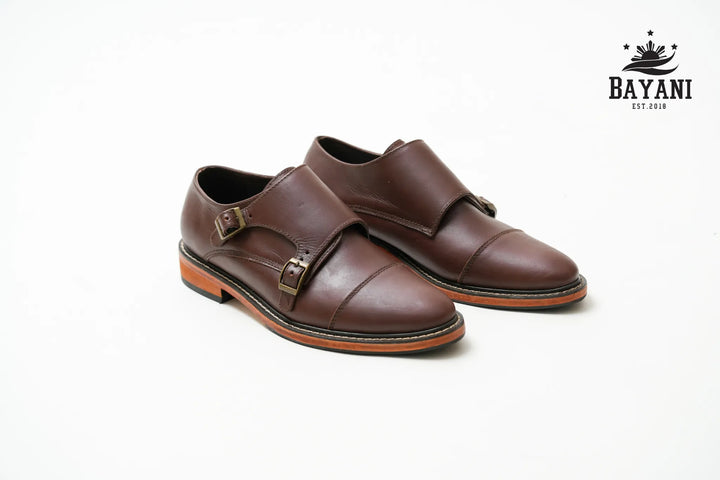 Black dress shoes on a white background with Bayani logo.
