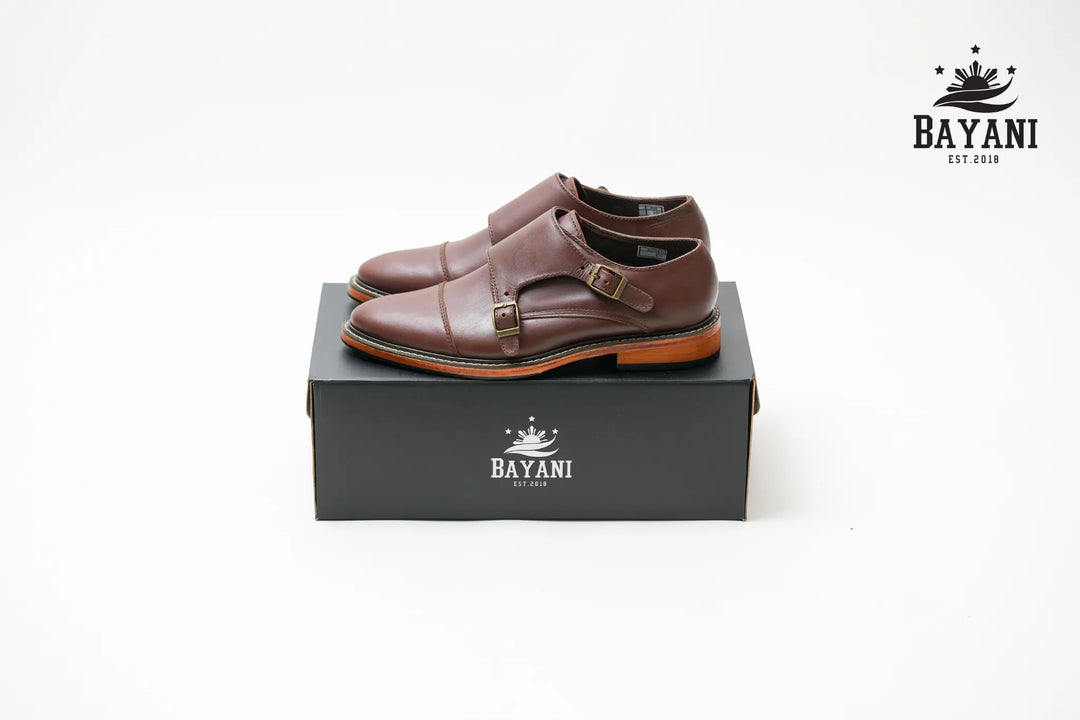 Brown dress shoes on a black Bayani box with the brand logo.
