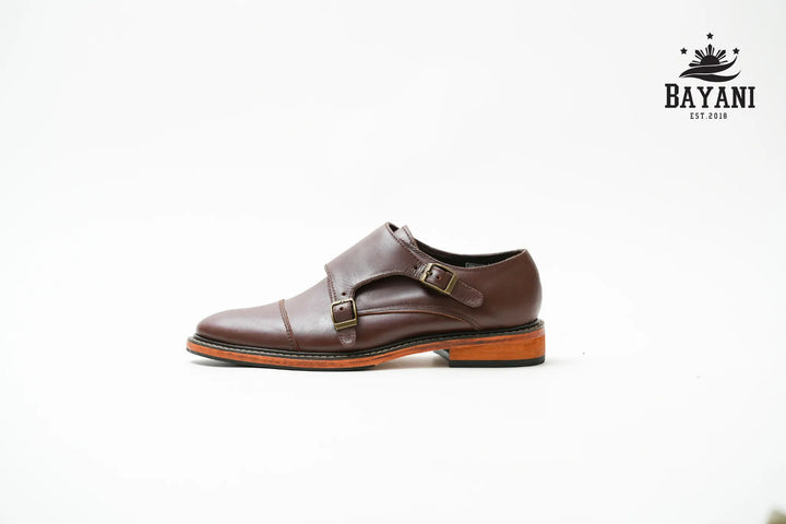 Brown leather shoe with a strap on a white background, featuring the Bayani brand.
