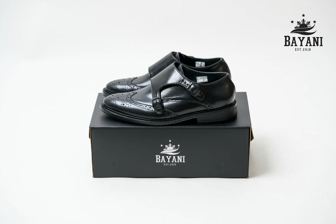 Black dress shoes on a Bayani branded box with the Bayani logo above.
