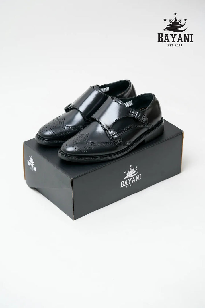 Black dress shoes on a Bayani branded box with the Bayani logo above.
