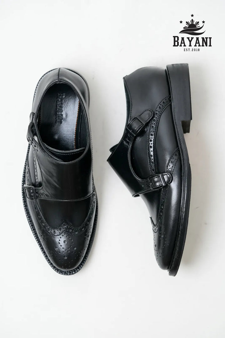 Pair of black dress shoes with a Bayani logo in the corner.
