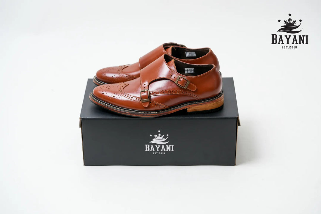 Brown leather shoes on a black box with Bayani logo on a white background

