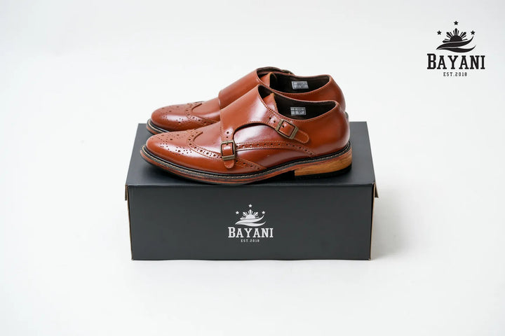 Brown leather shoes on a black box with Bayani logo on a white background
