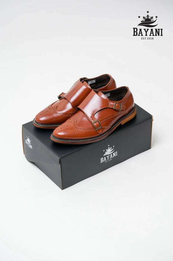 Brown leather shoes on a black shoe box with Bayani logo.
