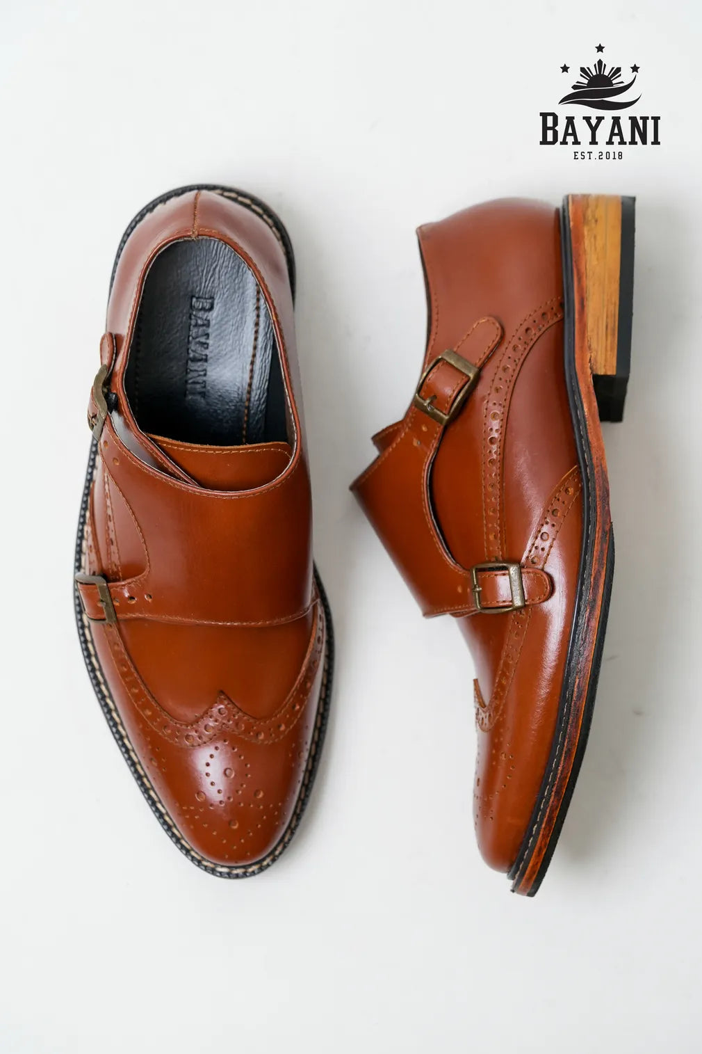 Pair of brown leather shoes with a visible brand logo on a white background
