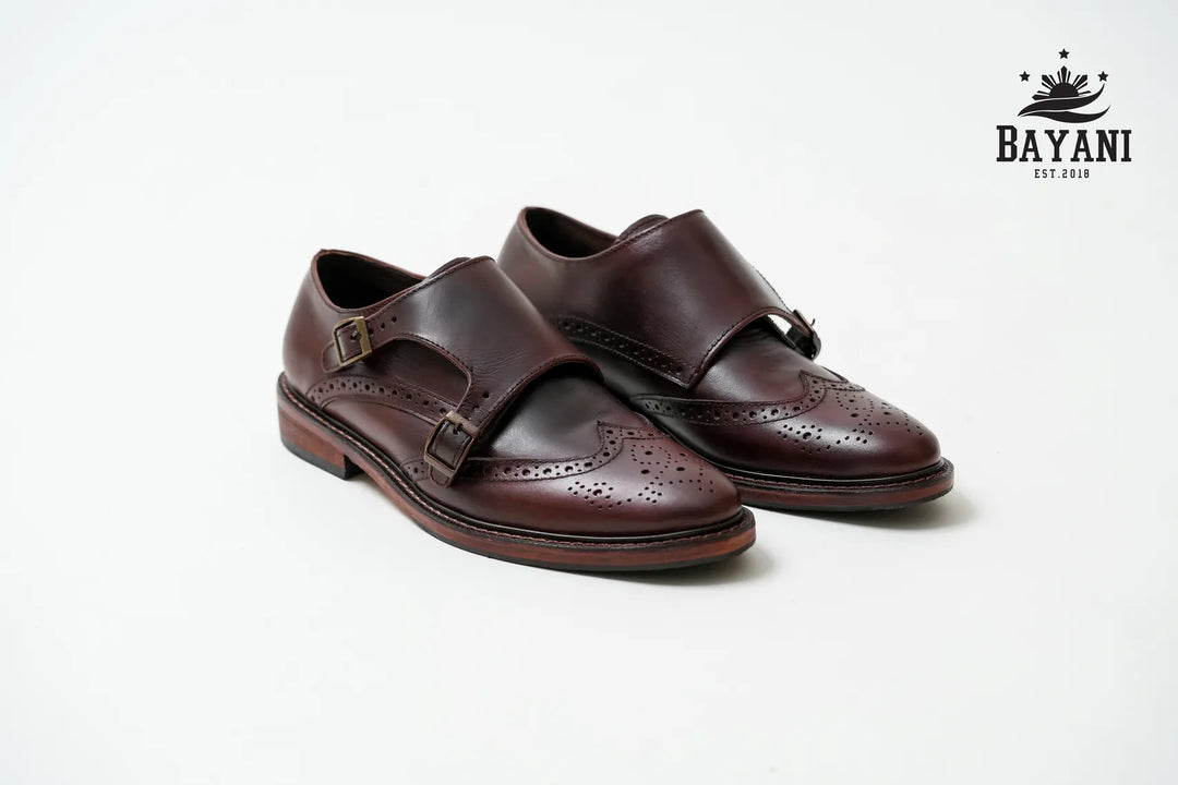 Pair of brown leather shoes on a white background with Bayani logo.
