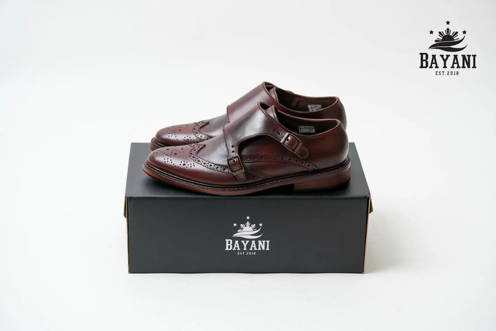 Brown leather shoes on a black box with Bayani logo on a white background
