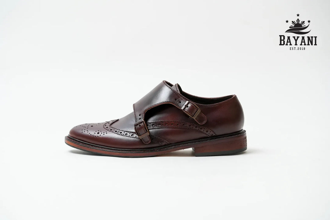 Brown leather shoe with a strap on a white background, featuring the Bayani logo.
