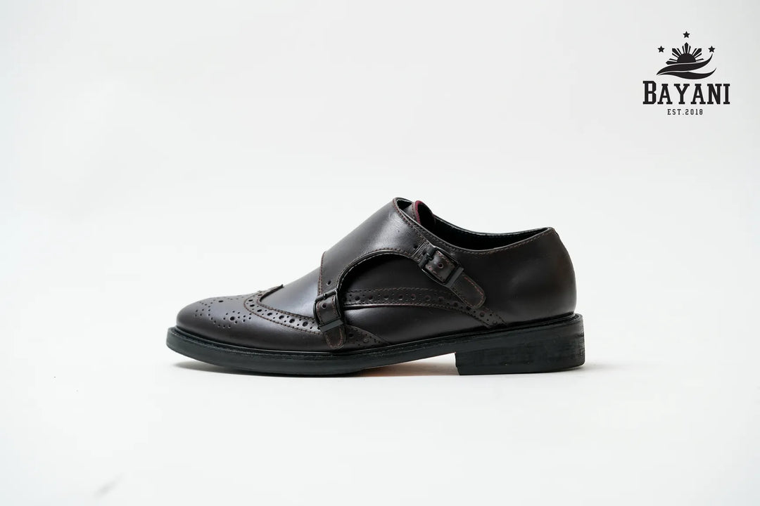 Black shoe with a strap on a white background, featuring the Bayani logo.
