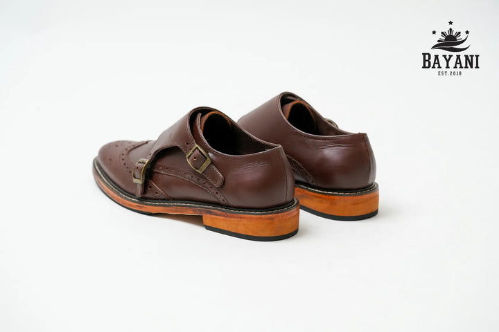 Brown leather shoes with a visible brand logo on a white background
