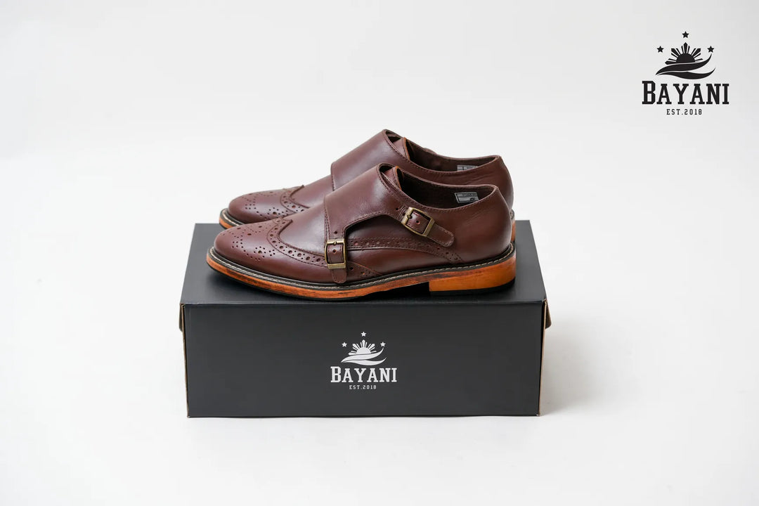 Brown sandals on a black box with Bayani logo on a white background

