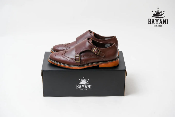 Brown sandals on a black box with Bayani logo on a white background
