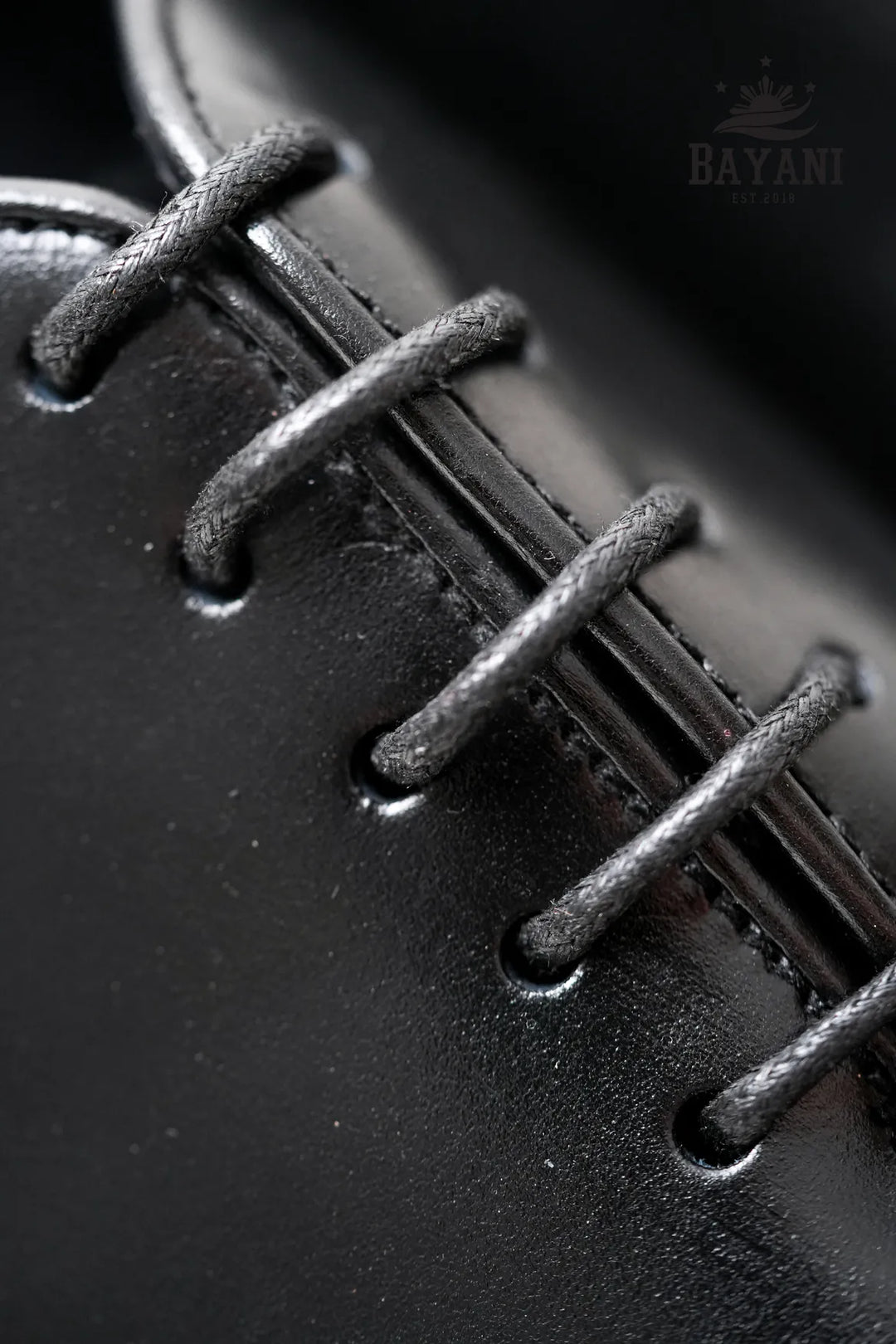 Close-up of black leather shoe laces with &