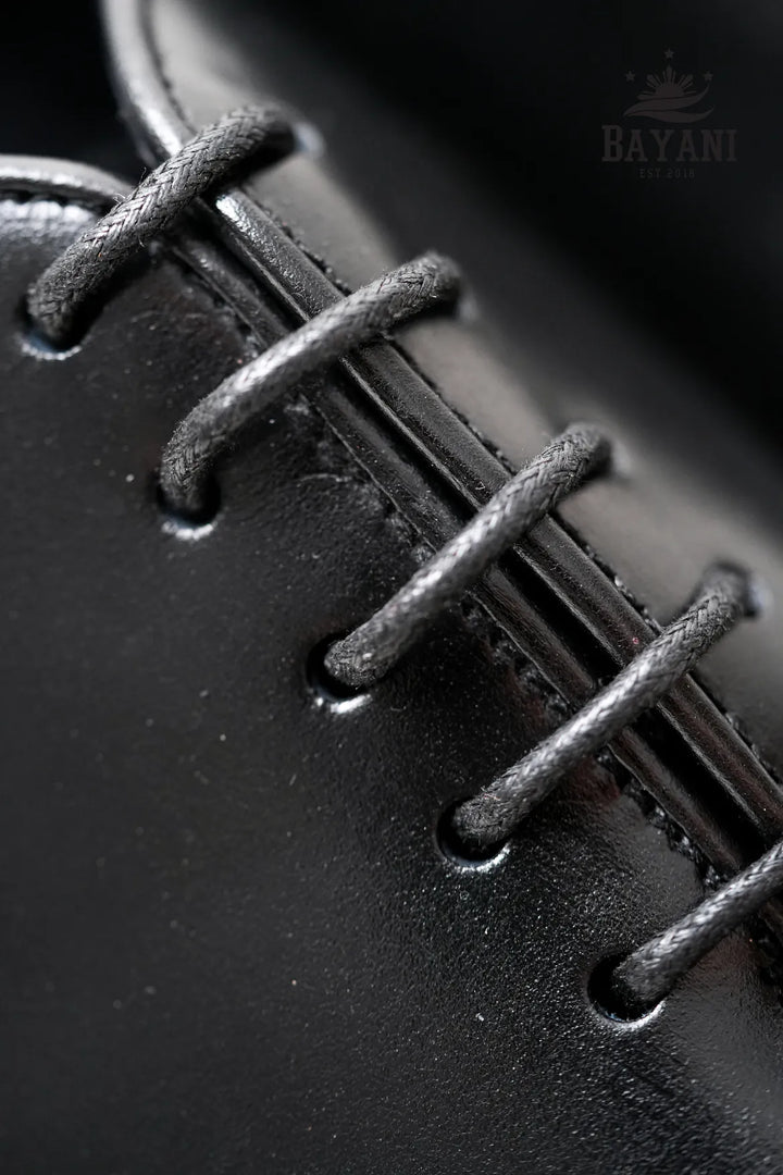 Close-up of black leather shoe laces with &