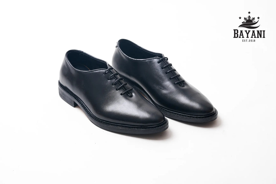 Pair of black leather shoes on a white background with Bayani logo.
#color_black