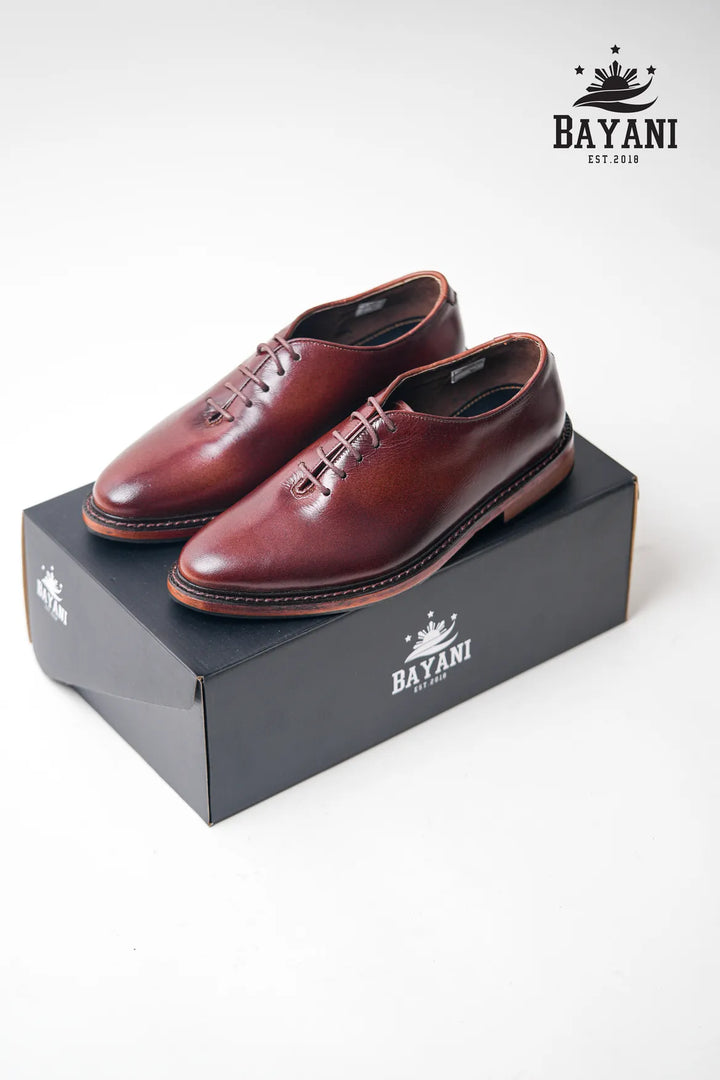 Brown leather shoes on a black Bayani box with the brand logo.
