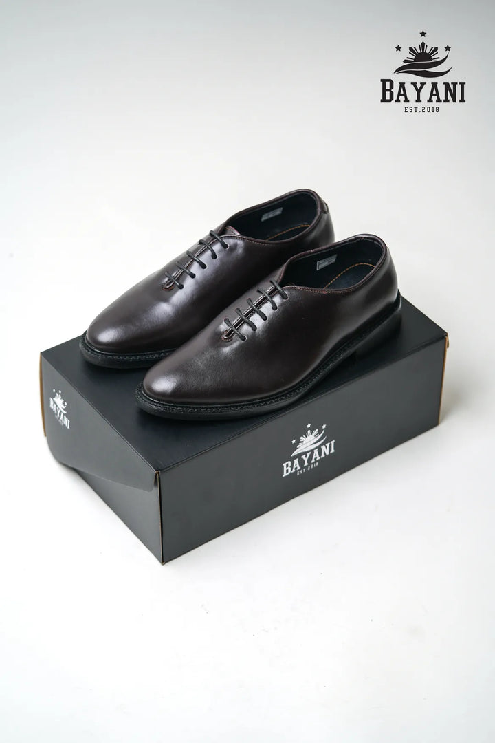 Black leather shoes on a black box with Bayani logo on a white background
